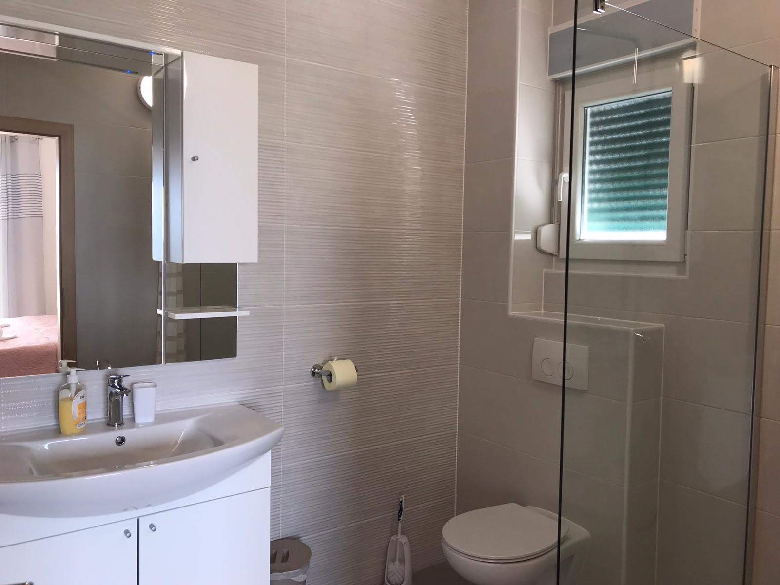 En-suite bathroom with separate toilet and glass-enclosed shower
