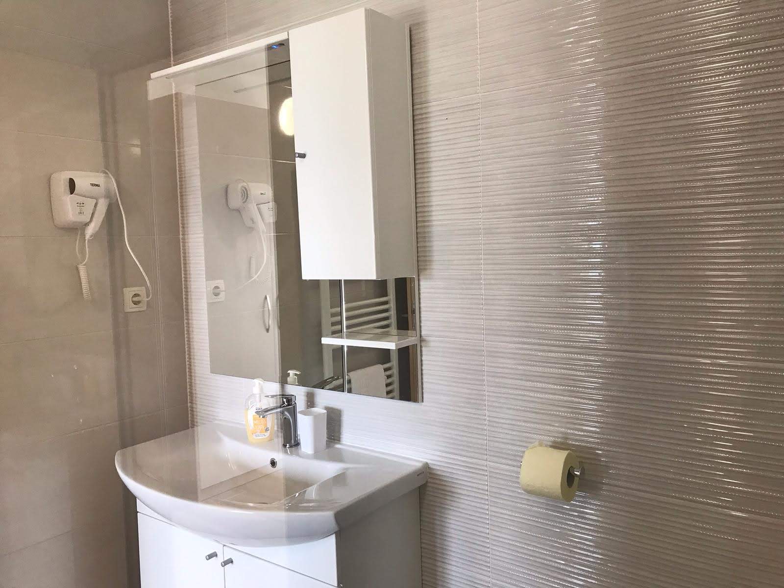 Bedroom with sea view and en-suite bathroom visible through open door