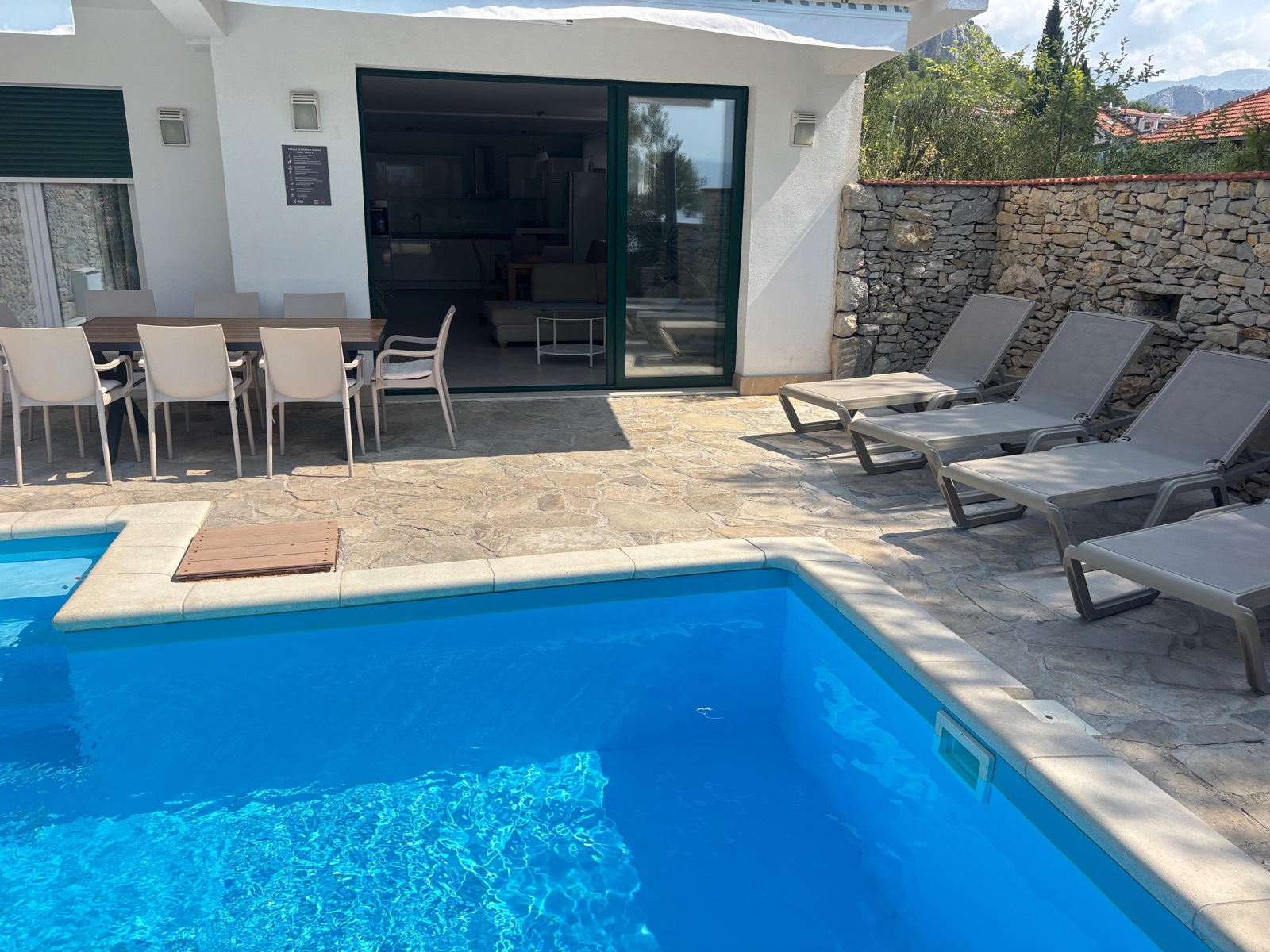 Villa exterior with pool, new sun loungers, and outdoor dining set