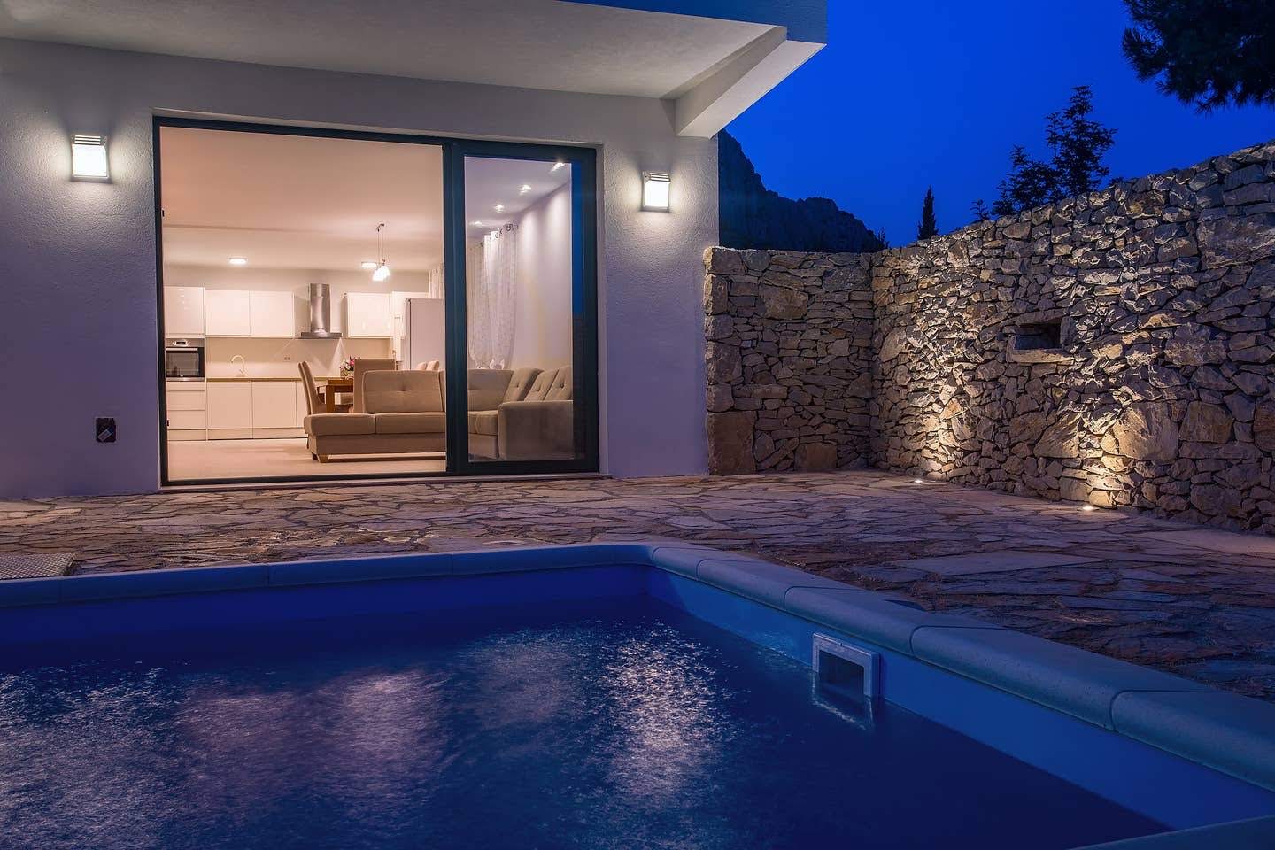 Pool lit at night with warm interior light